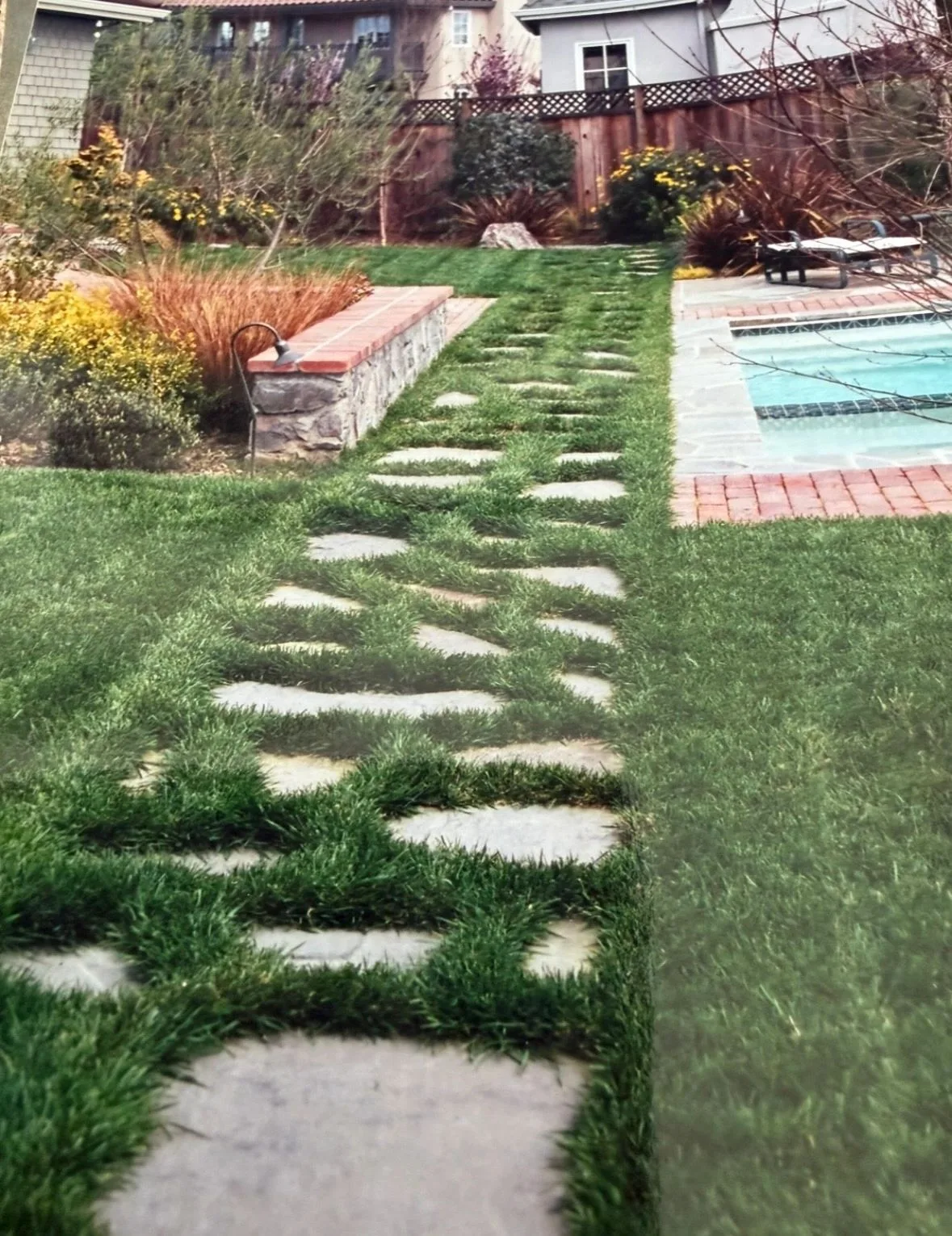 Irregular stepping stones crossing a green lawn