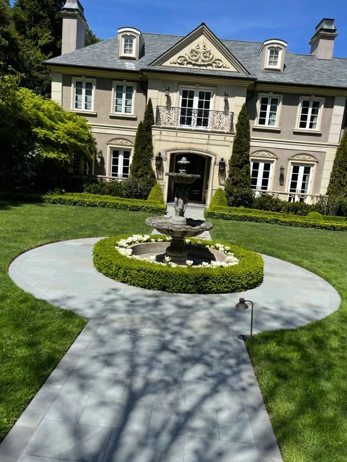 Elegant mansion with a central fountain and manicured garden court