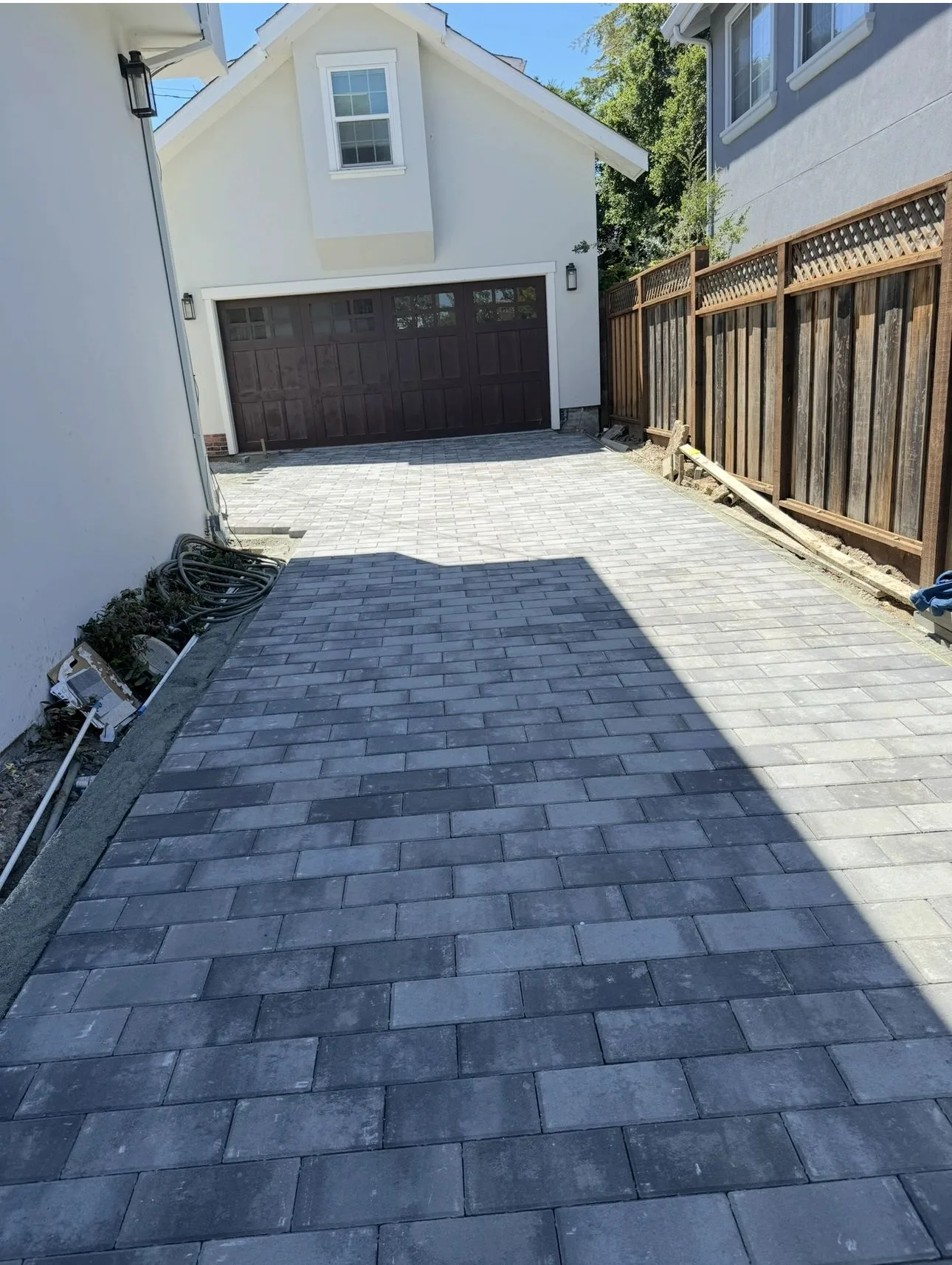 New gray paver driveway leading to a residential garage
