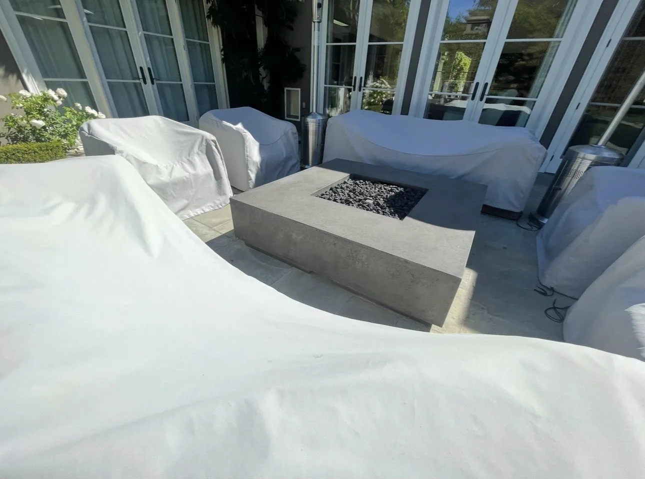 Square outdoor fire table set within a paved seating area