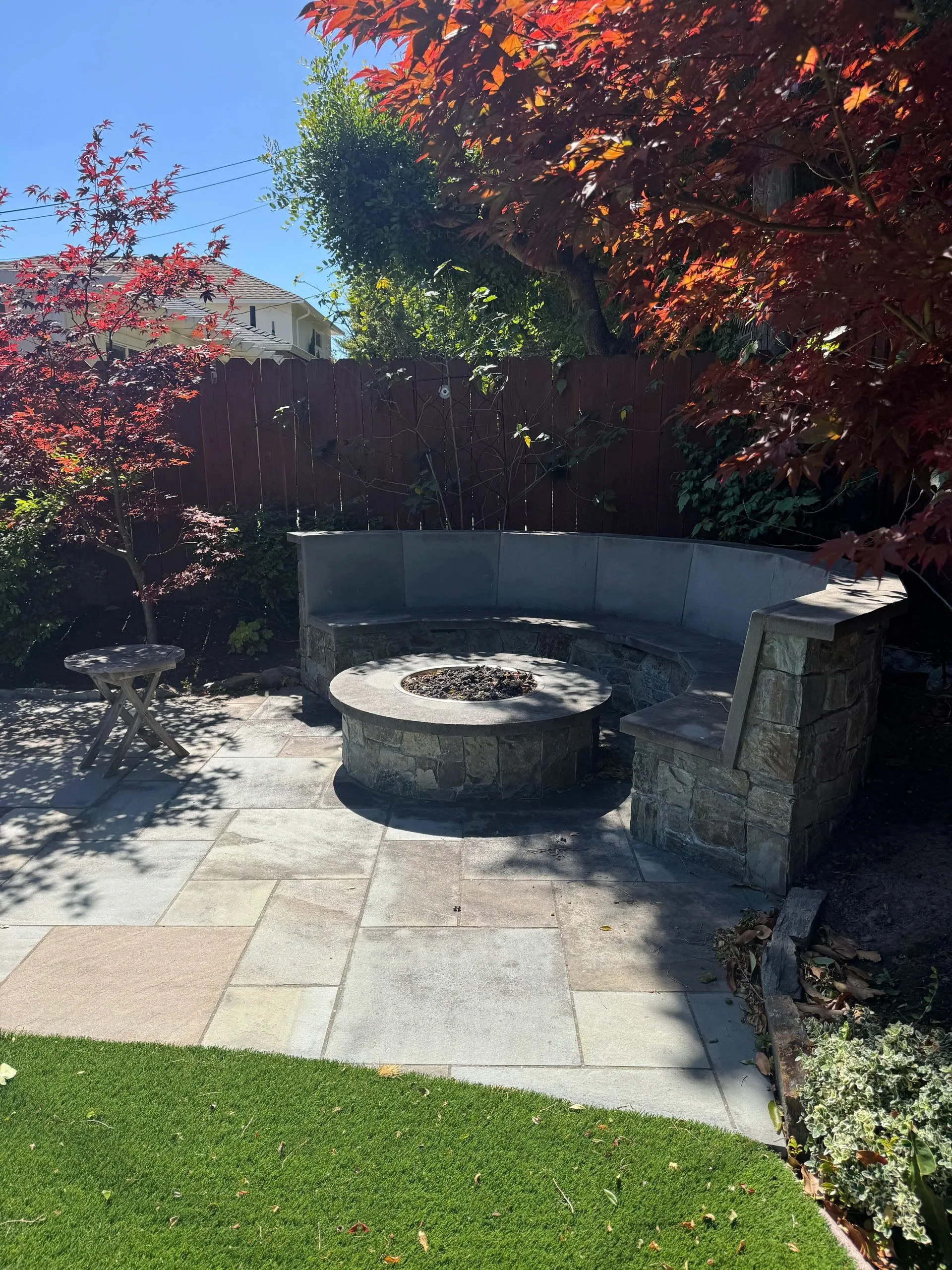 Circular stone firepit built into a paved patio