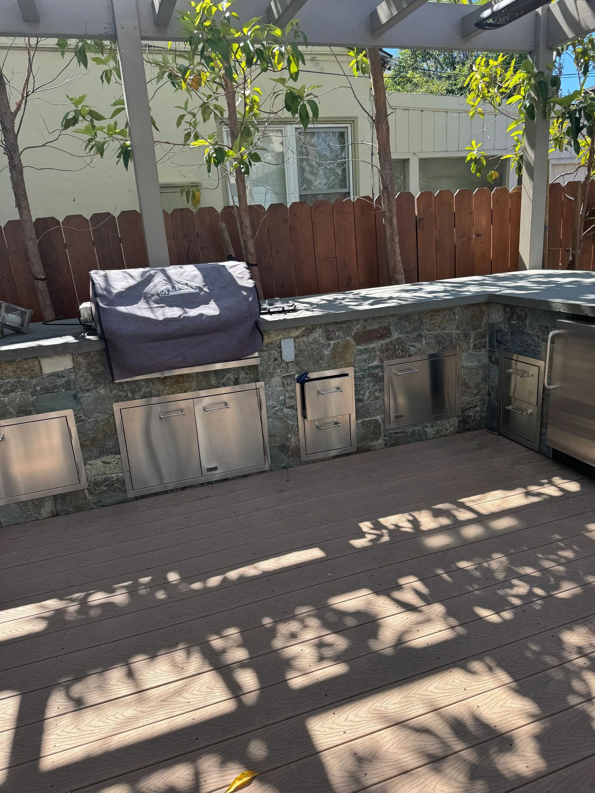 Timber deck and privacy fence casting linear afternoon shadows